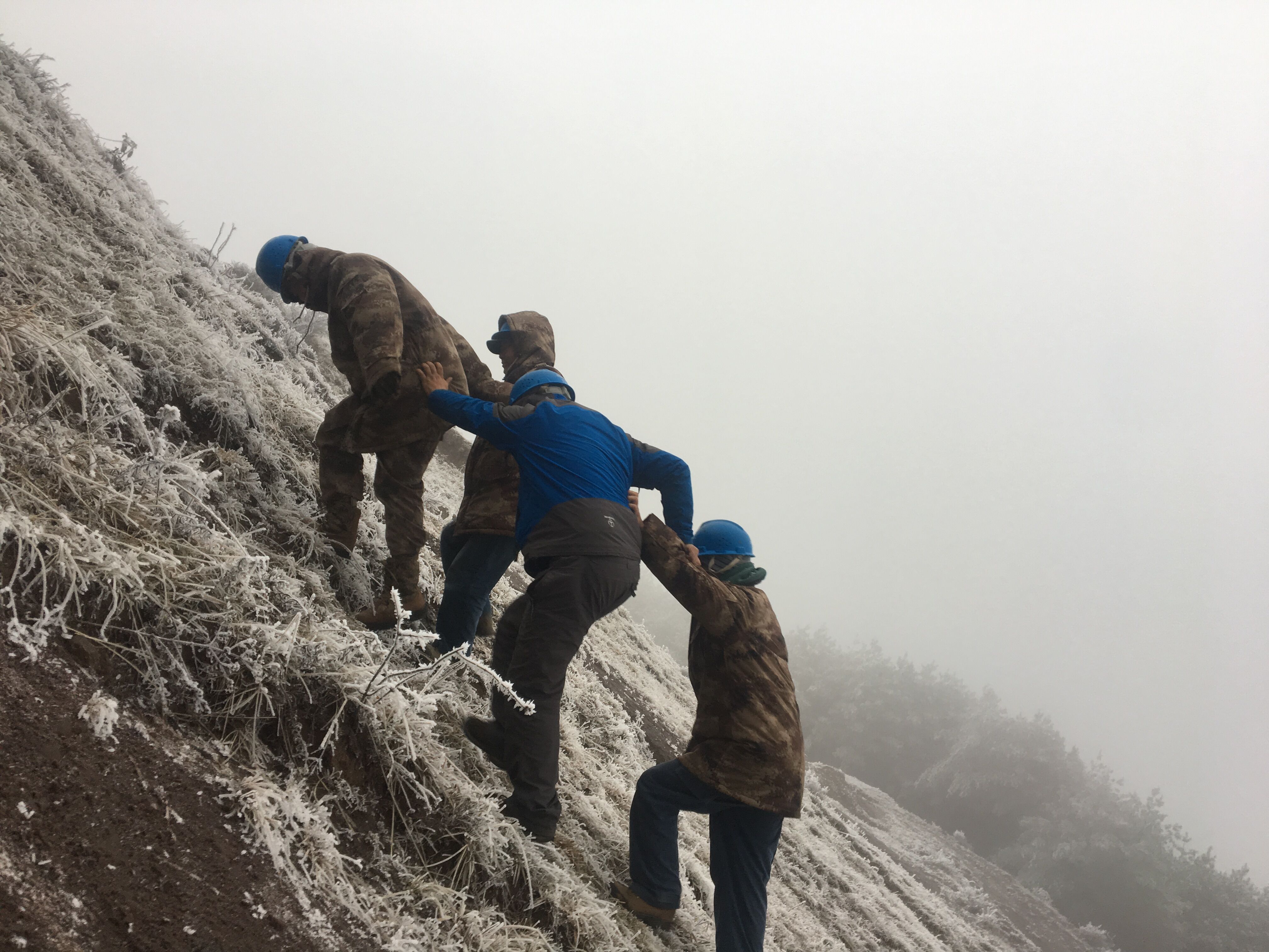 互相攙扶，勇登高峰。（李健攝）
